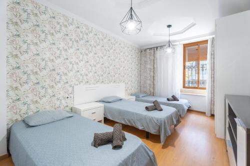 a room with three beds and a tv in it at Oasis de Valencia in Valencia