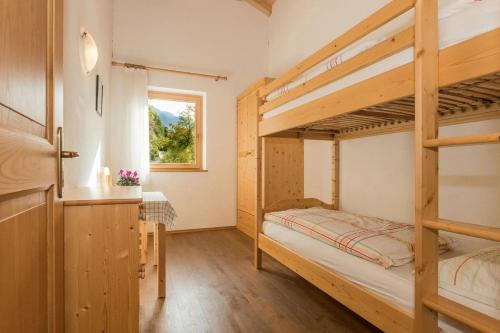 a bedroom with two bunk beds and a window at Pföslhof in Laives