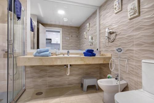 a bathroom with a sink and a toilet and a shower at La Casa De Los Sueños in Corralejo
