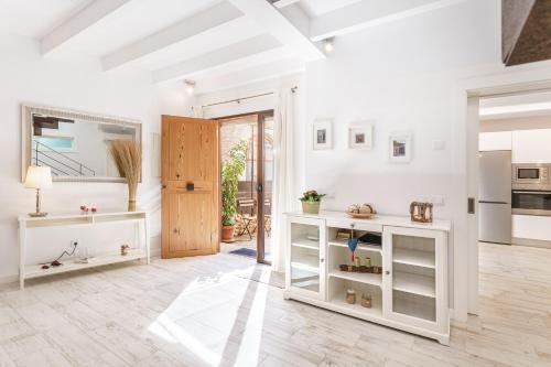 a white kitchen with white cabinets and a door at Es Raco in Costitx