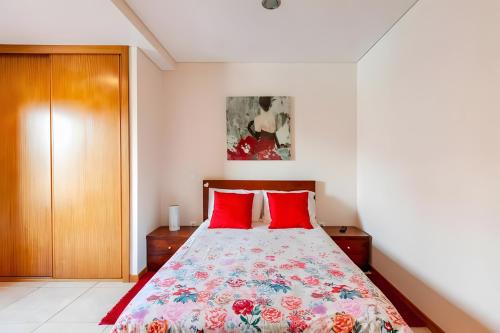 a bedroom with a bed with red pillows at Casa de Balinhas - Gerês in Ventosa