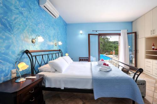 a bedroom with a bed with a blue wall at Villa Casa Bianca Blue Apartment in Gaios