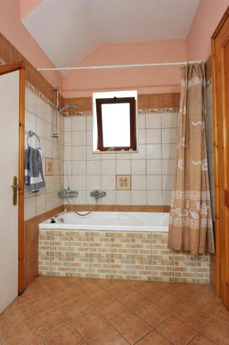 a bath tub in a bathroom with a window at Villa Casa Bianca Blue Apartment in Gaios