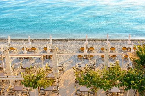 a beach with chairs and umbrellas and the ocean at Akrata Beach Hotel in Akrata