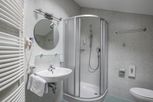 a bathroom with a sink and a shower with a mirror at Apartment Arnika - Mesnerhof in Sand in Taufers