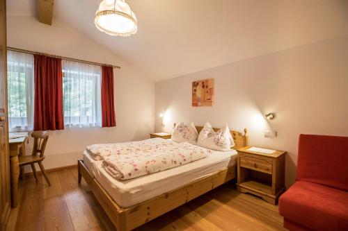 a bedroom with a bed and a table and a chair at Apartment Arnika - Mesnerhof in Sand in Taufers