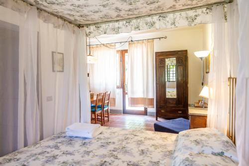 a bedroom with a bed and a table and chairs at Birbina - Poggio alle Birbe in Il Bagno