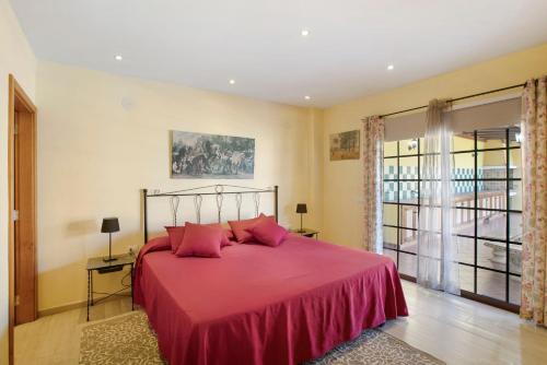 a bedroom with a large red bed with pink pillows at Villa Tazana in Icod de los Vinos
