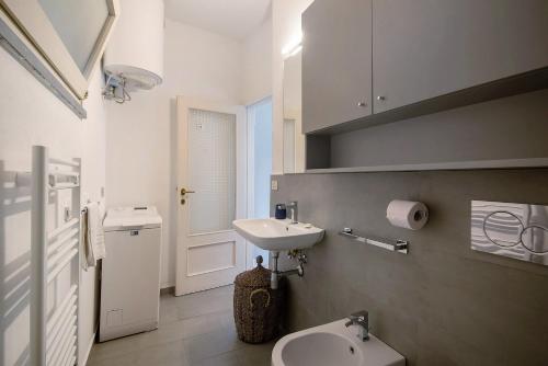 a white bathroom with a sink and a toilet at Via Colombo 12 - Trilocale in Bonassola