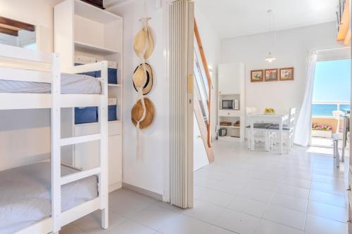 a room with bunk beds and a hallway with a kitchen at Sunrise Medes in Torroella de Montgrí