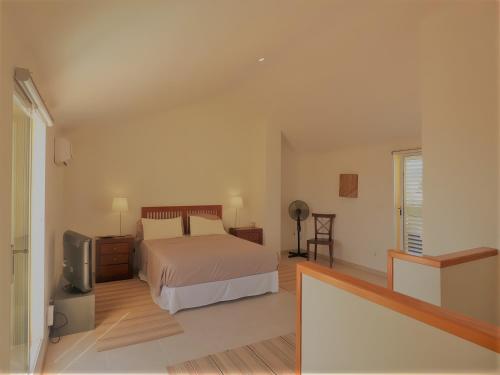 a bedroom with a bed and a television in it at Ático en Jávea - Solo Familias 1813 in Platja de l'Arenal