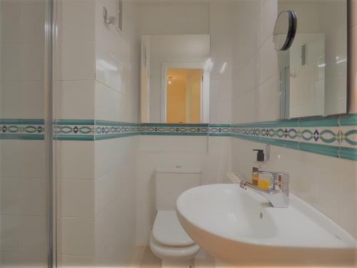 a white bathroom with a sink and a toilet at Ático en Jávea - Solo Familias 1813 in Platja de l'Arenal