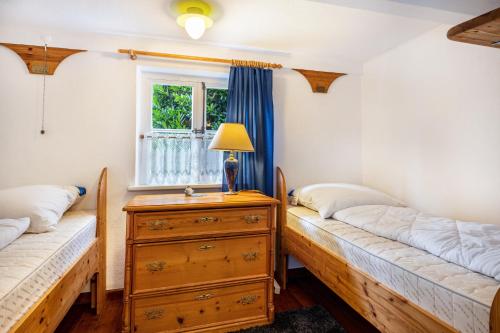 two beds in a room with a dresser and a window at Deichkate Deichwinkel in Drochtersen