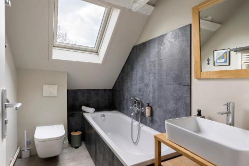 a bathroom with a white tub and a sink at Les Ecuries - La Trigalière in Ambillou