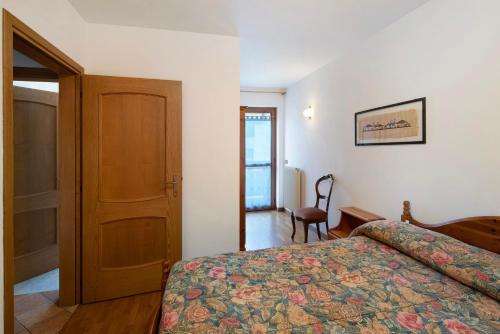 a bedroom with a bed and a wooden door at Residence Malibu Appartamento 9 in Falcade
