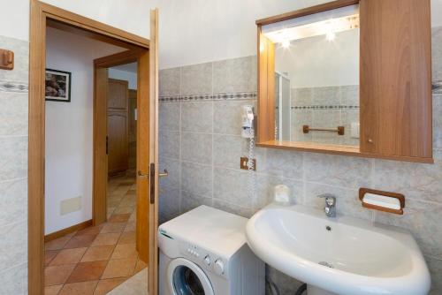 a bathroom with a sink and a washing machine at Residence Malibu Appartamento 9 in Falcade