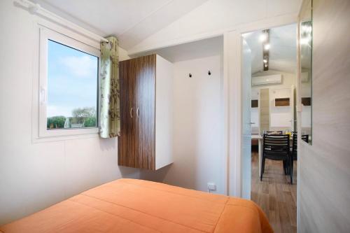a bedroom with a bed and a window and a dining room at Bungalow T3 i i i - 15 Min Nazaré in Pataias