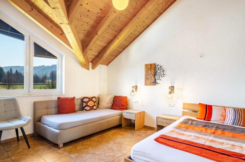 a bedroom with a bed and a couch and a window at Obstgut Mit Herz Thomas Maier in Stockach