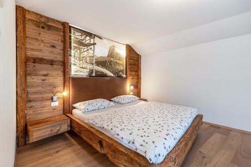 a bedroom with a bed and a painting on the wall at Naturoase Stegerhof Apt Ringelblume in Trodena