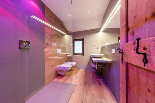a purple bathroom with a toilet and a sink at Naturoase Stegerhof Apt Ringelblume in Trodena
