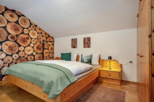 a bedroom with a bed and a wall of logs at Ferienwohnung Carlina in Pfronten