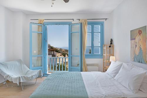 a bedroom with a bed and a large window at Efrossyni House in Ioulis