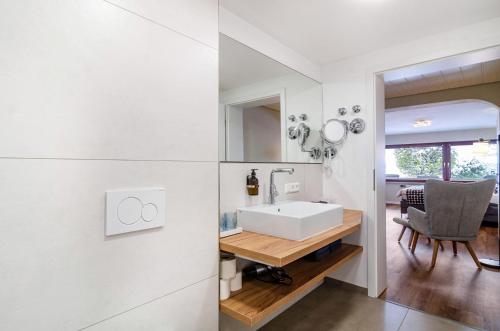 a bathroom with a sink and a desk with a chair at Ferienwohnung Behling in Frickingen
