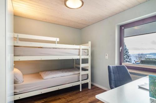 a bedroom with bunk beds and a desk and a window at Ferienwohnung Behling in Frickingen