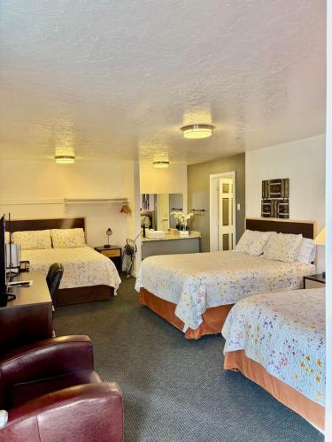 a hotel room with two beds and a chair at Motel West in Bend