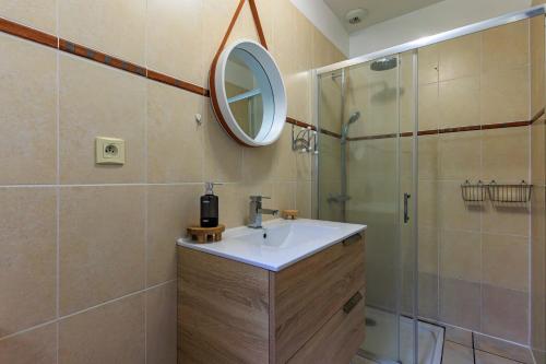 a bathroom with a sink and a shower with a mirror at Villa Melchivany - Nature et Océan in Messanges