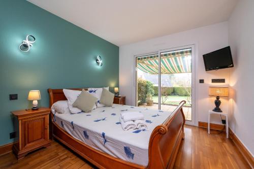 a bedroom with a bed and a large window at Maison entre terre et mer in Pluvigner