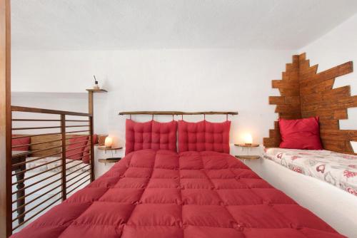 a bedroom with a large bed with red pillows at Nel Cuore della Via Francigena in Aosta