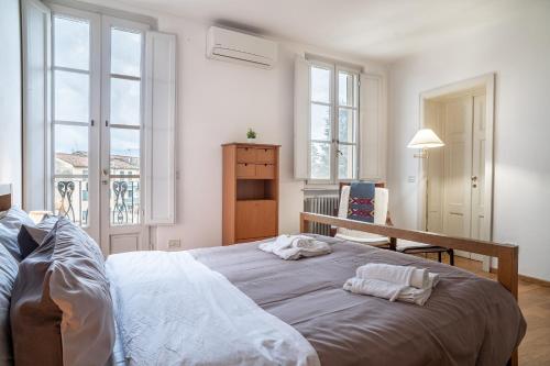 a bedroom with a large bed with two towels on it at Chica's Lucca Luxury Loft in Lucca