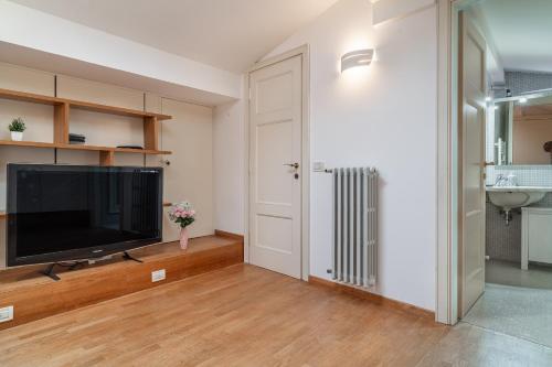 a living room with a flat screen tv next to a door at Chica's Lucca Luxury Loft in Lucca