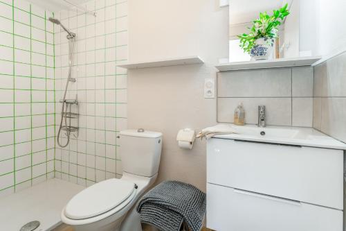 a white bathroom with a toilet and a sink at La Tonnelle, clim, jardin in Malaucène