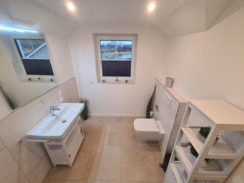 a white bathroom with a sink and a toilet at Emily in Geeste