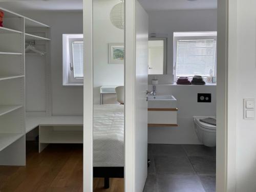 a white bathroom with a toilet and a sink at Ferienwohnung Peterberg 22, 45qm in Kirchzarten