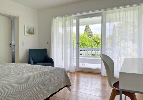 a bedroom with a bed and a chair and a window at Ferienwohnung Peterberg 22, 45qm in Kirchzarten