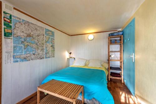 a small bedroom with a bed and a map on the wall at Studio vue sur mer in Plomodiern