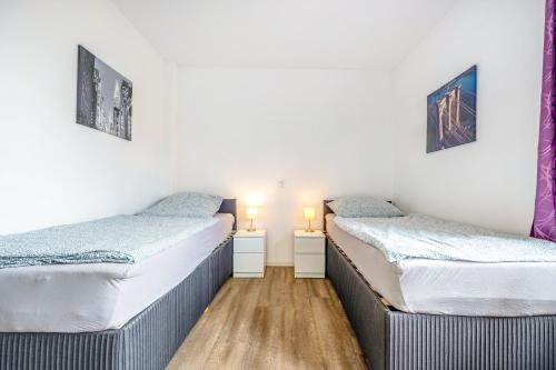 two twin beds in a room with two lamps at Kleine Himmelpforte in Himmelpforten