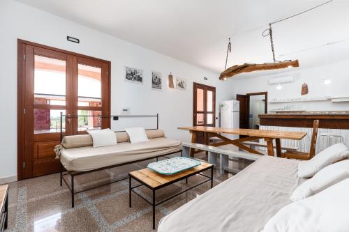 a living room with two beds and a table at Villa Pedduzza in Orosei