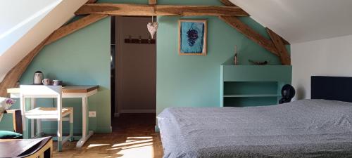 a bedroom with a bed and a table in a room at Chambres D'hôtes Les Préaux - in Cérans-Foulletourte