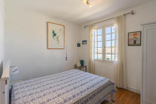 ein Schlafzimmer mit einem Bett und einem Fenster in der Unterkunft La Presqu'ile in Talmont