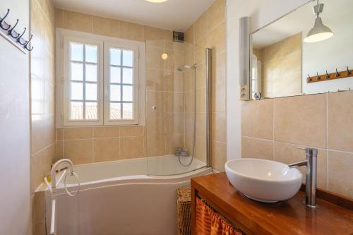 ein Badezimmer mit Badewanne, Waschbecken und Badewanne in der Unterkunft La Presqu'ile in Talmont