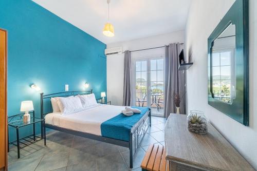 a bedroom with a bed with a blue wall at Spyridoula Studio 4 in Paleokastritsa