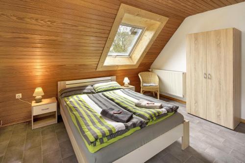 a bedroom with a bed with a wooden wall at Tati's Ferienwohnung Siegerland in Hilchenbach