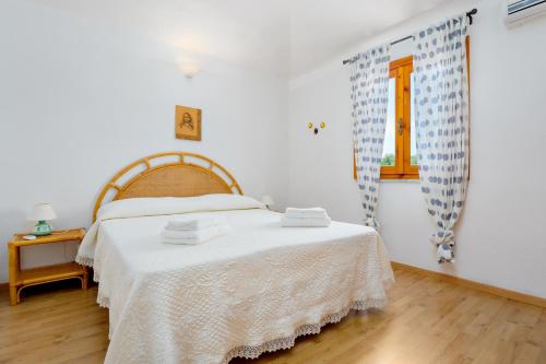 a bedroom with a bed with a white blanket at Casa Asfodeli in San Teodoro