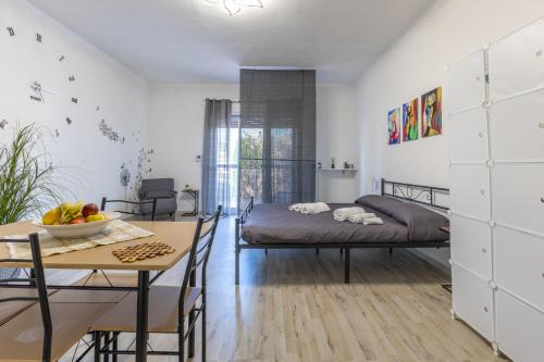 a bedroom with a bed and a table and a dining room at Villa Tosca dell'Angelo con piscina in Comiso