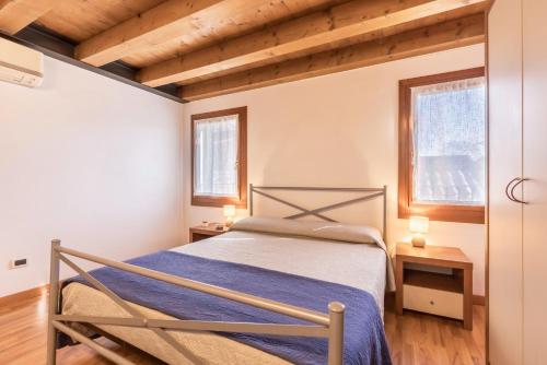 a bedroom with a bed and two windows at Casa Giuly in Mirano