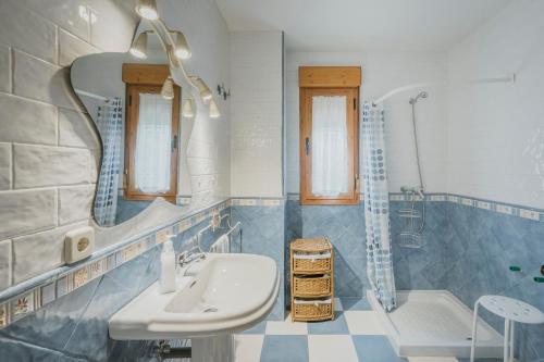 a blue and white bathroom with a sink and a shower at Los Molinillos in Caballar